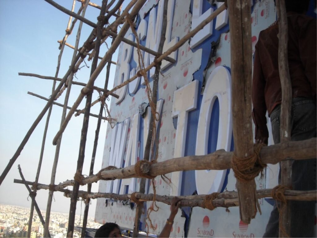 3D acrylic LED sign board installation on high-rise building by signage experts in Hyderabad, Kondapur.