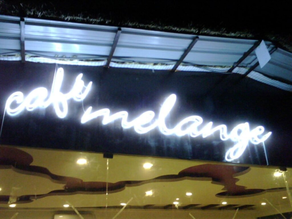White neon café signage designed and installed by Sina Interior & Signage in Hyderabad for restaurants, cafés, coffee shops, and hospitality businesses.