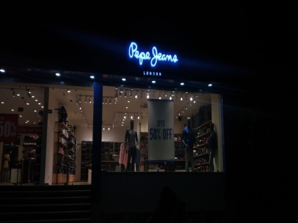 Retail storefront signage with illuminated brand logo installed by Sina Interior & Signage in Hyderabad for clothing and fashion outlets.