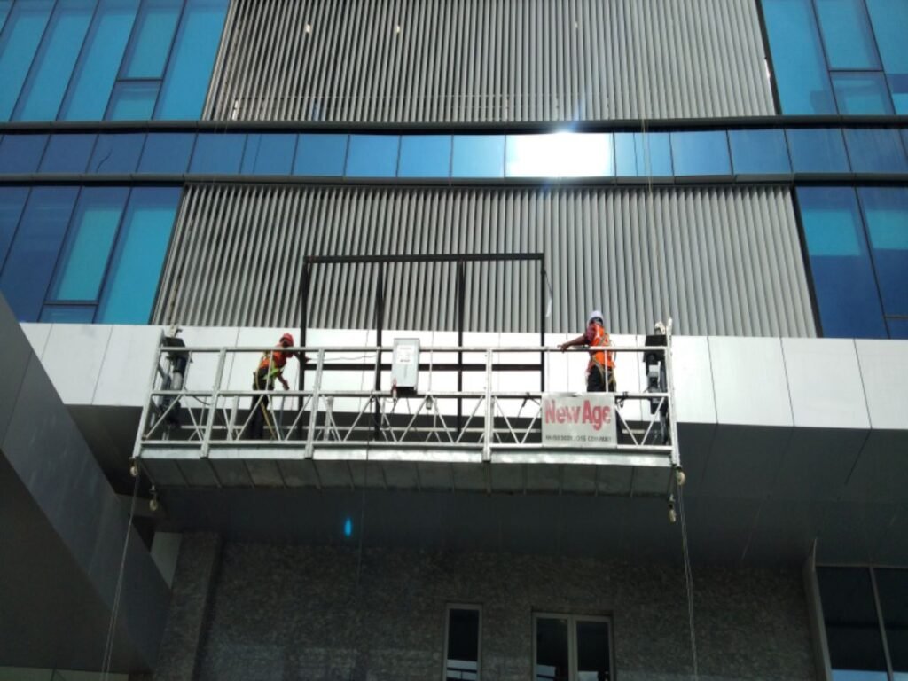 Professional high-rise building signage installation by Sina Interior & Signage in Hyderabad using suspended access platforms for safe exterior branding.