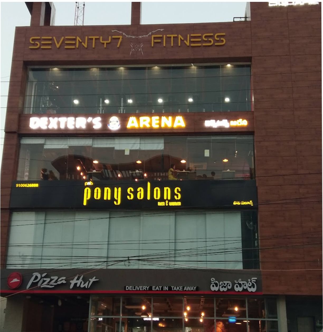 Modern ACP facade with LED sign boards and premium commercial building branding in Hyderabad, Begumpet.